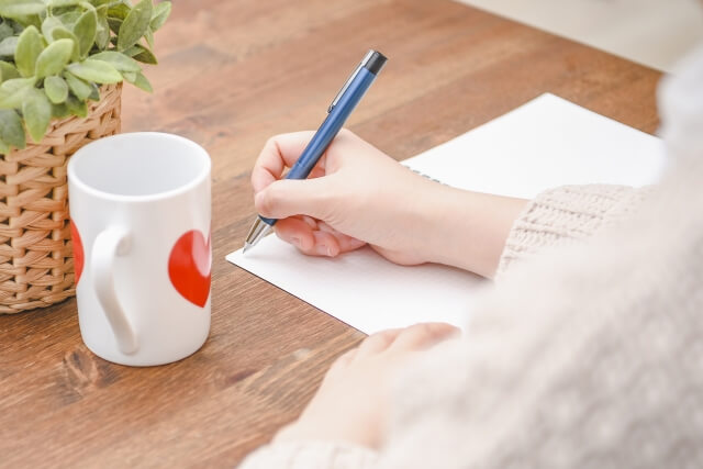 手帳にメモを書きながら整理する様子