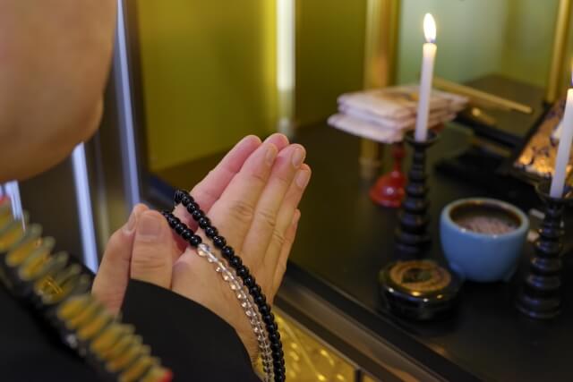 寺院で手を合わせて供養している様子