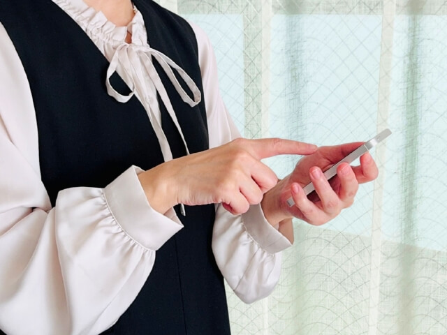 スマートフォンで連絡をしている様子