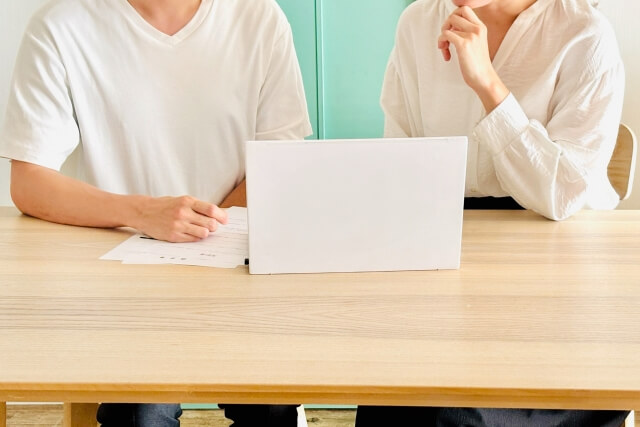 四十九日までの準備について書類を見ながら相談する様子