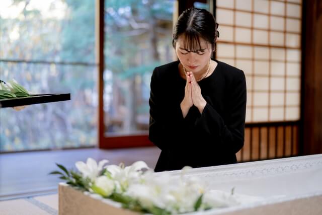 故人様へ静かに手を合わせる参列者