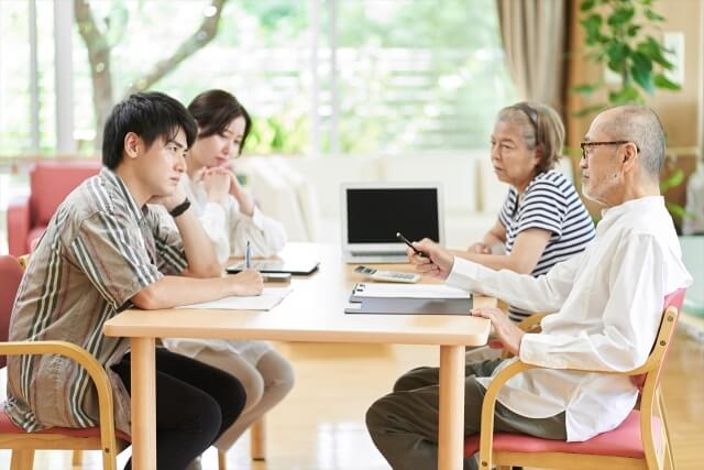 テーブルを囲んで話し合う家族
