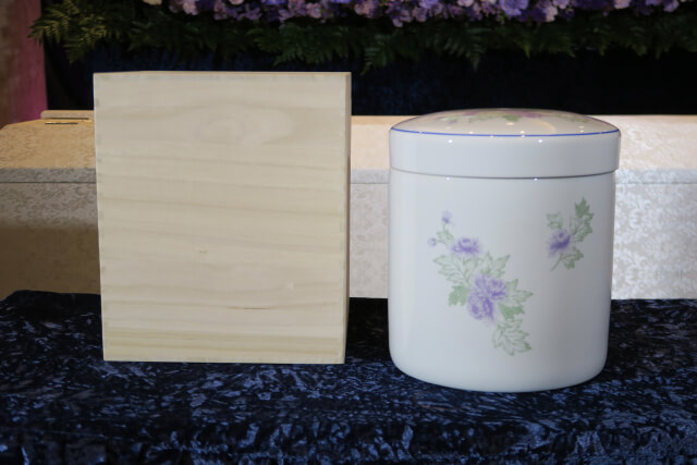 木製の骨箱と花柄の骨壺