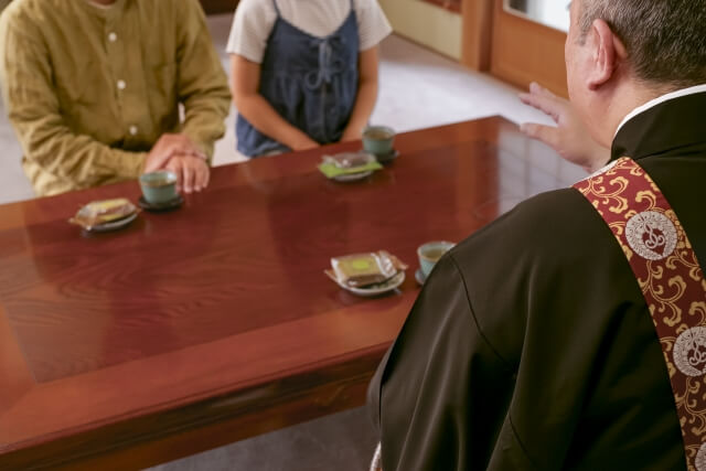 僧侶と向かい合って話す二人