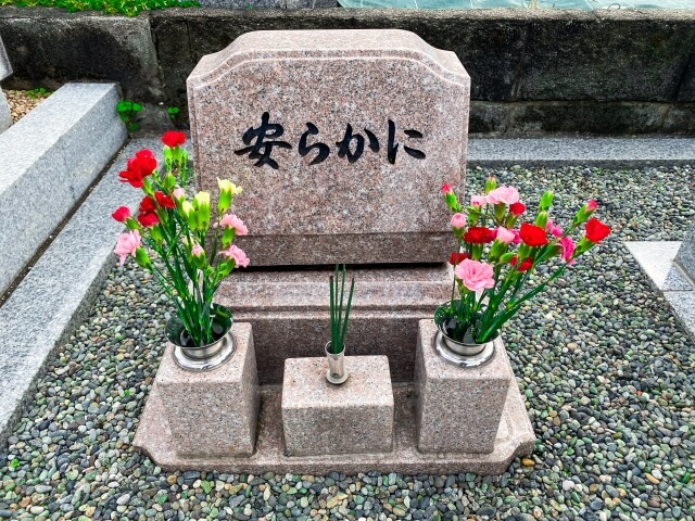 花と線香が供えられたペットの墓