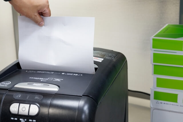 紙をシュレッダーに入れる手元